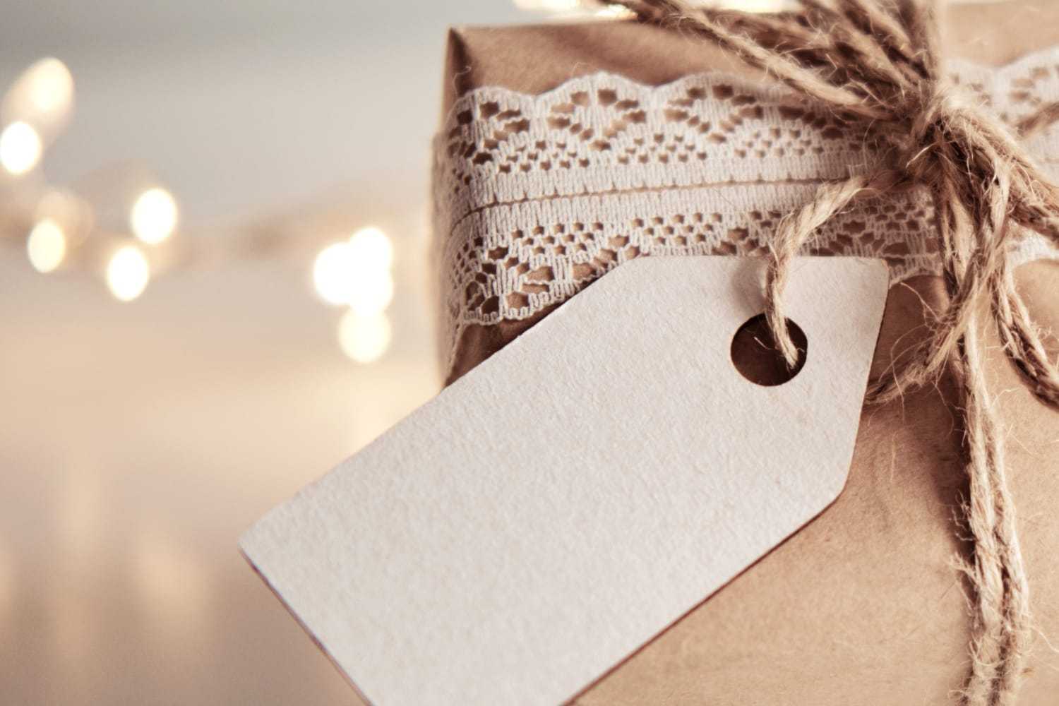 Gift wrapped in brown paper with lace ribbon and twine, featuring a blank tag.